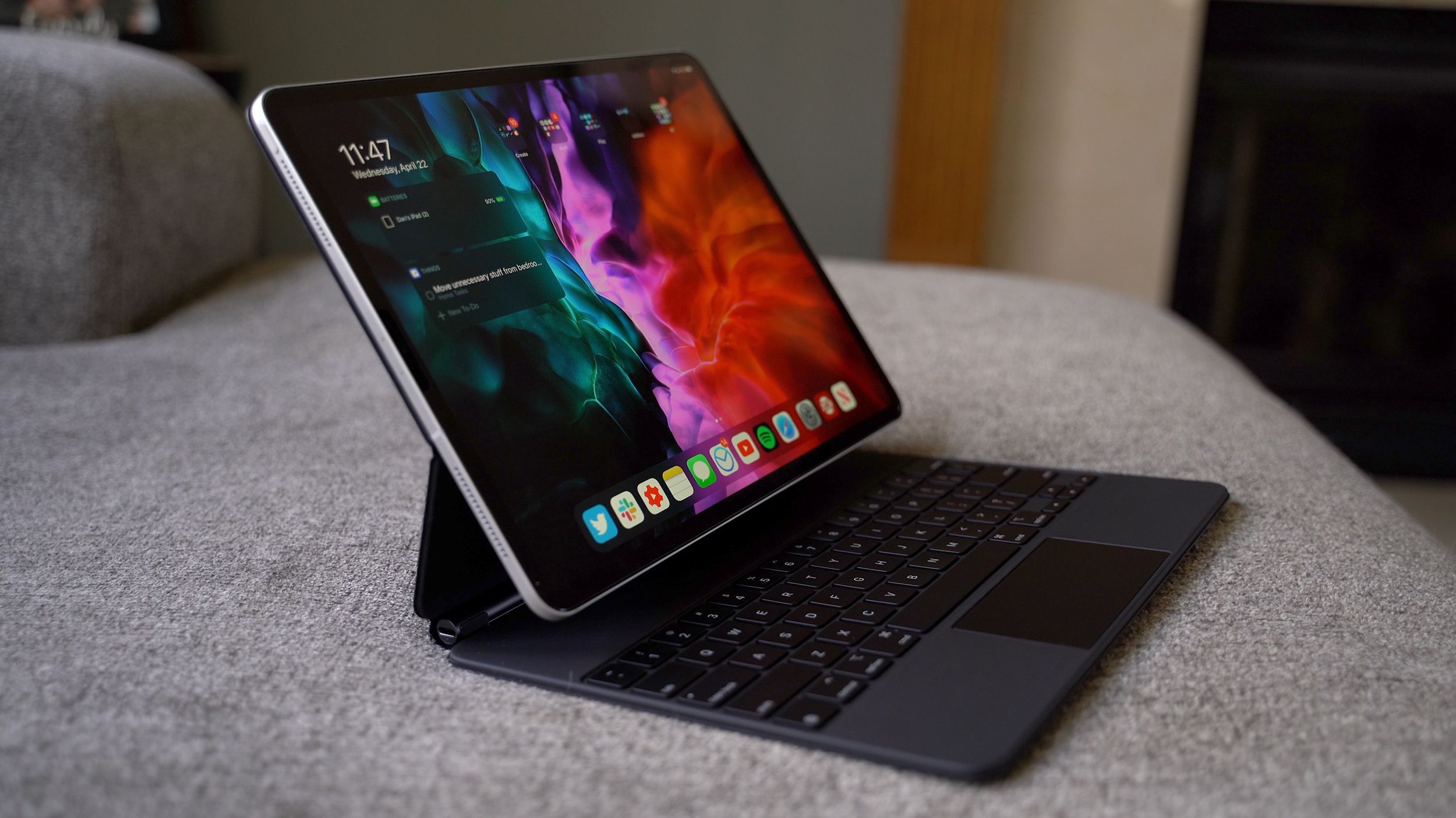  A black Apple Magic Keyboard and Apple Pencil Pro sit on a gray couch.